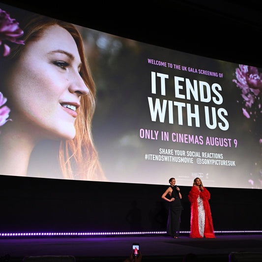 UK gala screening event for It Ends With Us movie with two women speaking on stage and large film poster